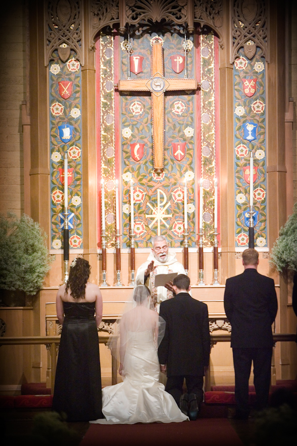 Bride and groom kneel at altar - wedding photo by J Garner Photography